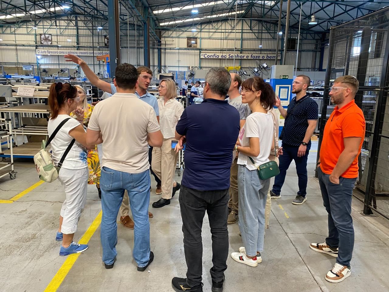 Um grupo de pessoas está em um armazém conversando entre si.
