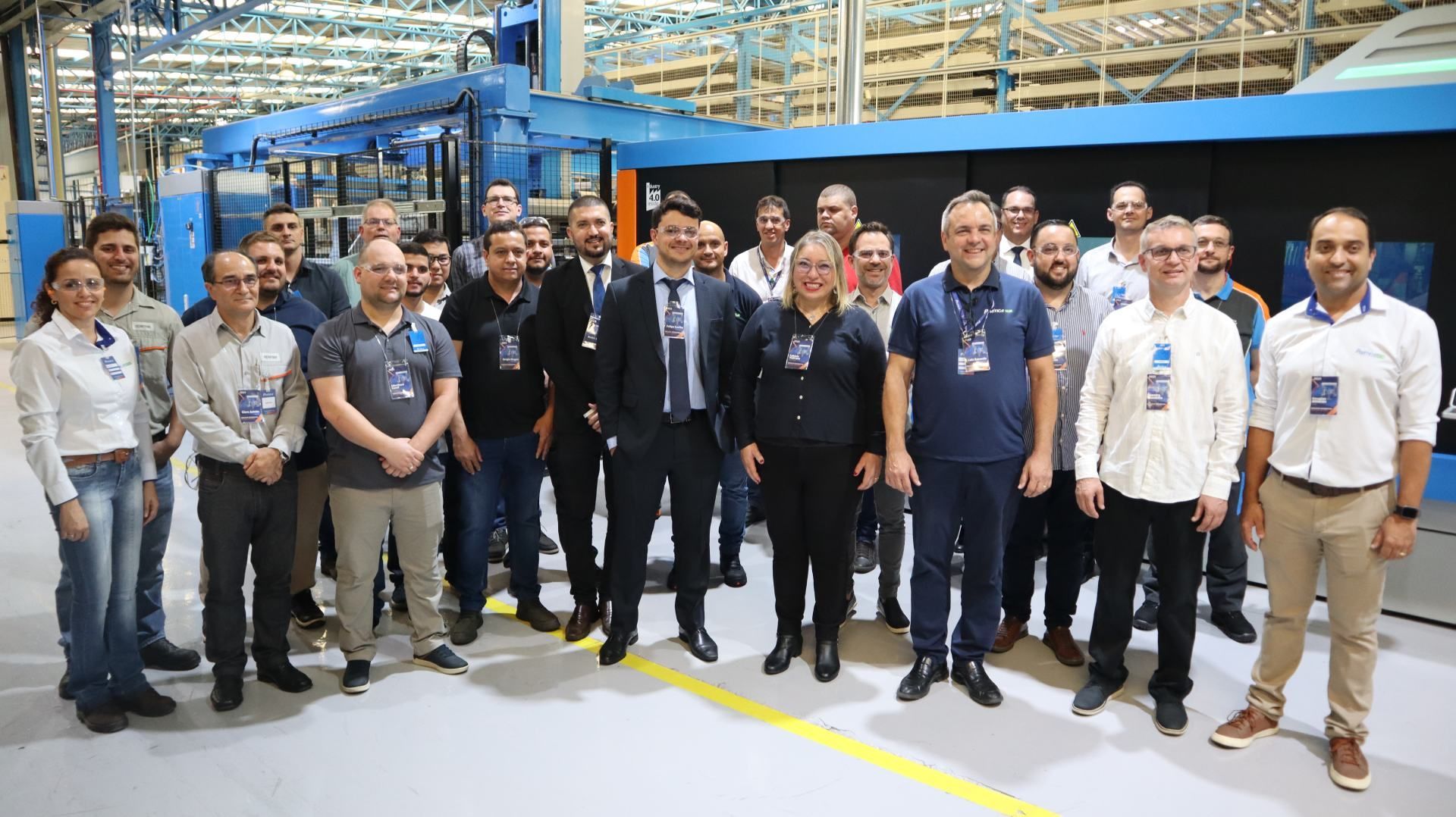 Um grupo de pessoas está posando para uma foto em uma fábrica.