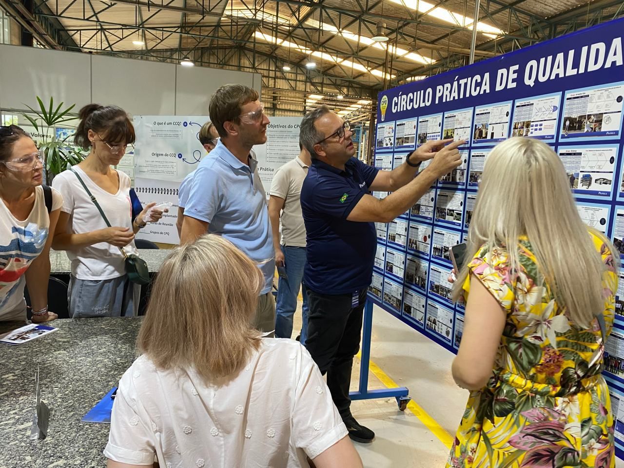 Um grupo de pessoas está olhando para um quadro com imagens.