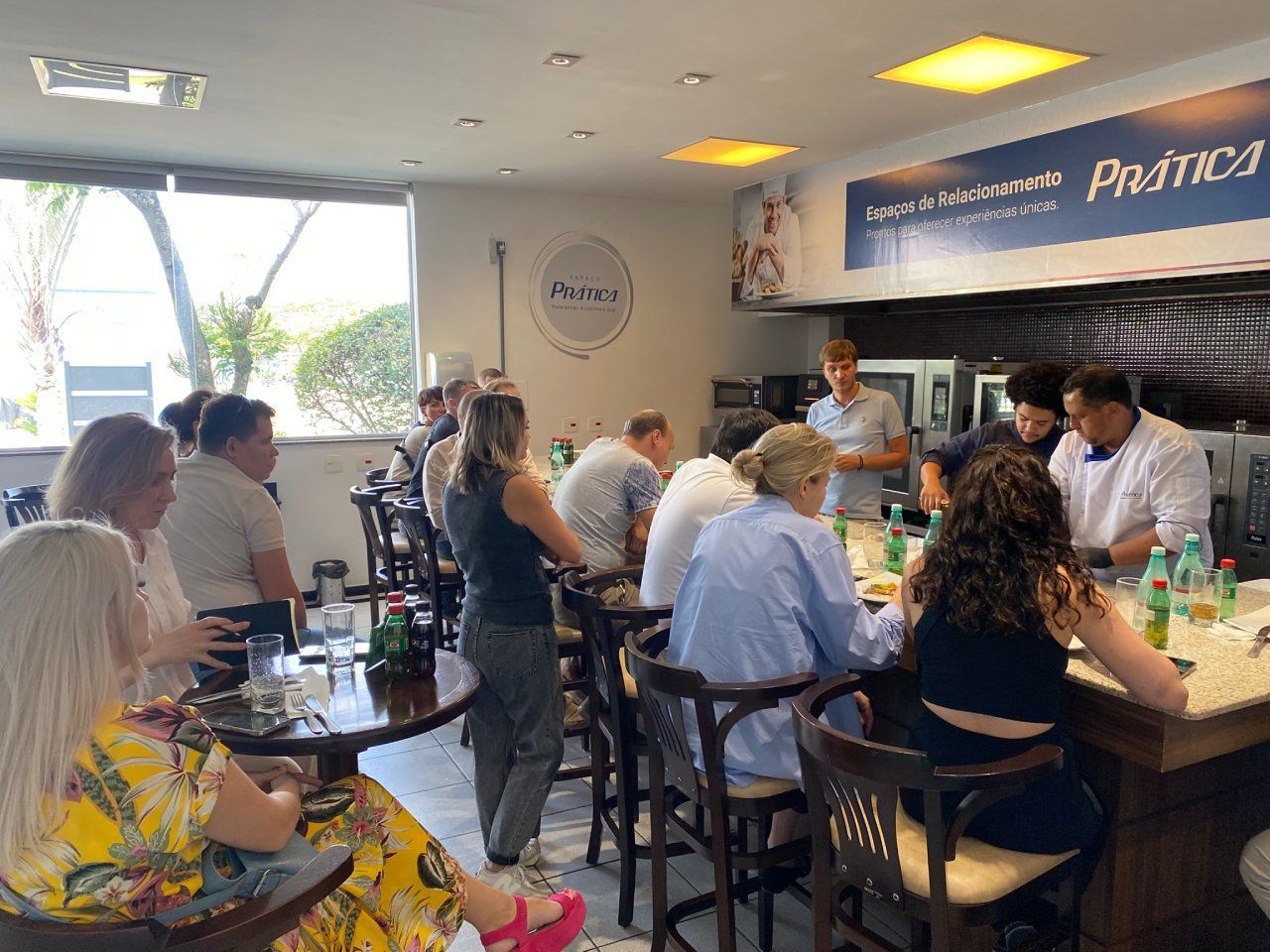 Um grupo de pessoas está sentado em mesas em um restaurante.