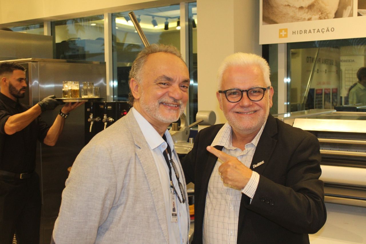 Dois homens estão posando para uma foto e um está apontando para a câmera