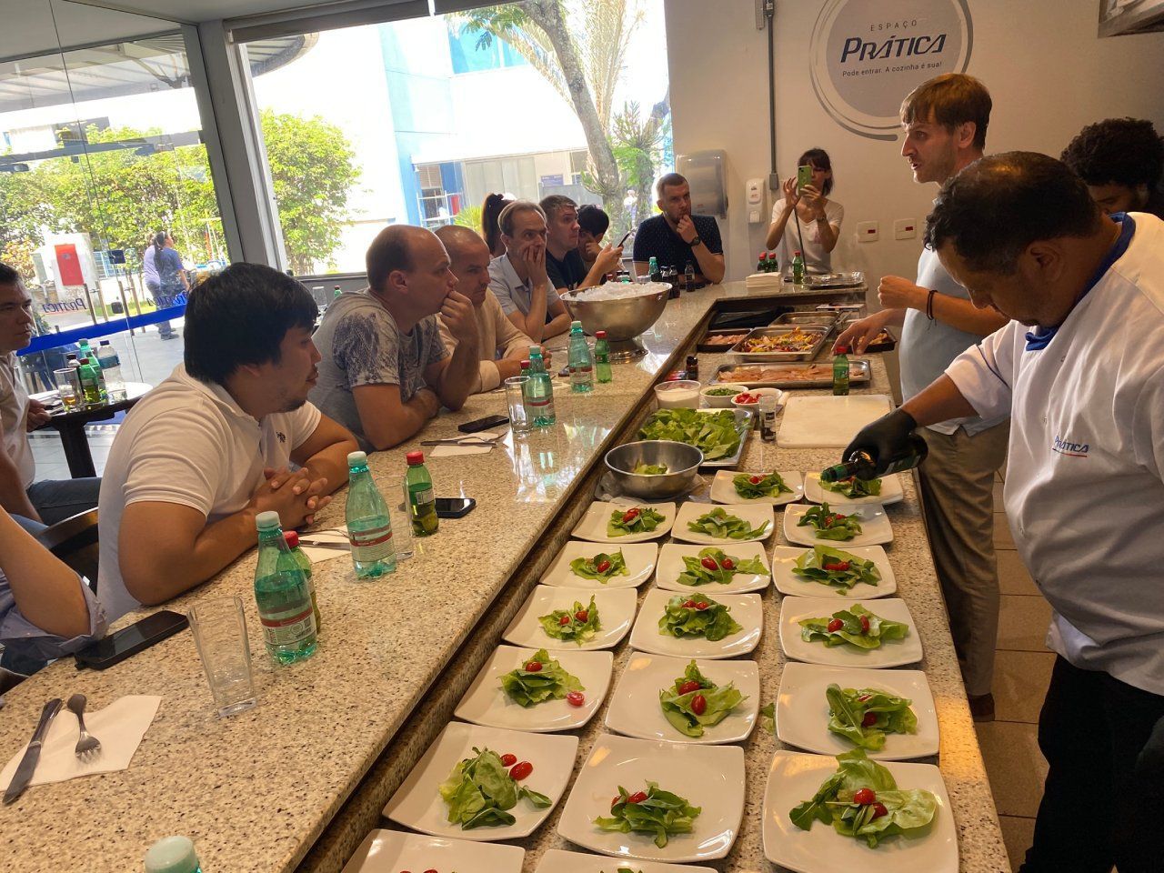 Um grupo de pessoas está sentado à mesa com pratos de comida.