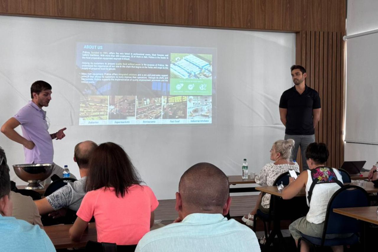 Um homem está fazendo uma apresentação para um grupo de pessoas em uma sala de aula.