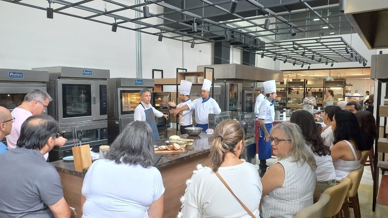 Um grupo de pessoas está sentado em um restaurante observando um chef preparar comida.