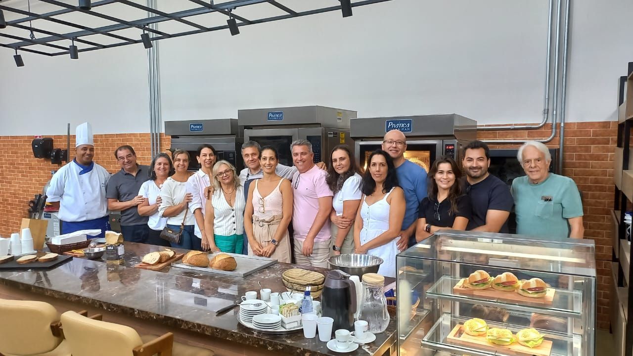 Um grupo de pessoas está posando para uma foto em uma padaria.