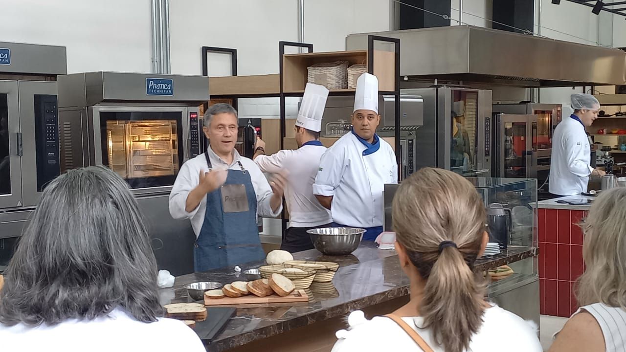 Um grupo de pessoas está assistindo a uma aula de culinária em uma cozinha