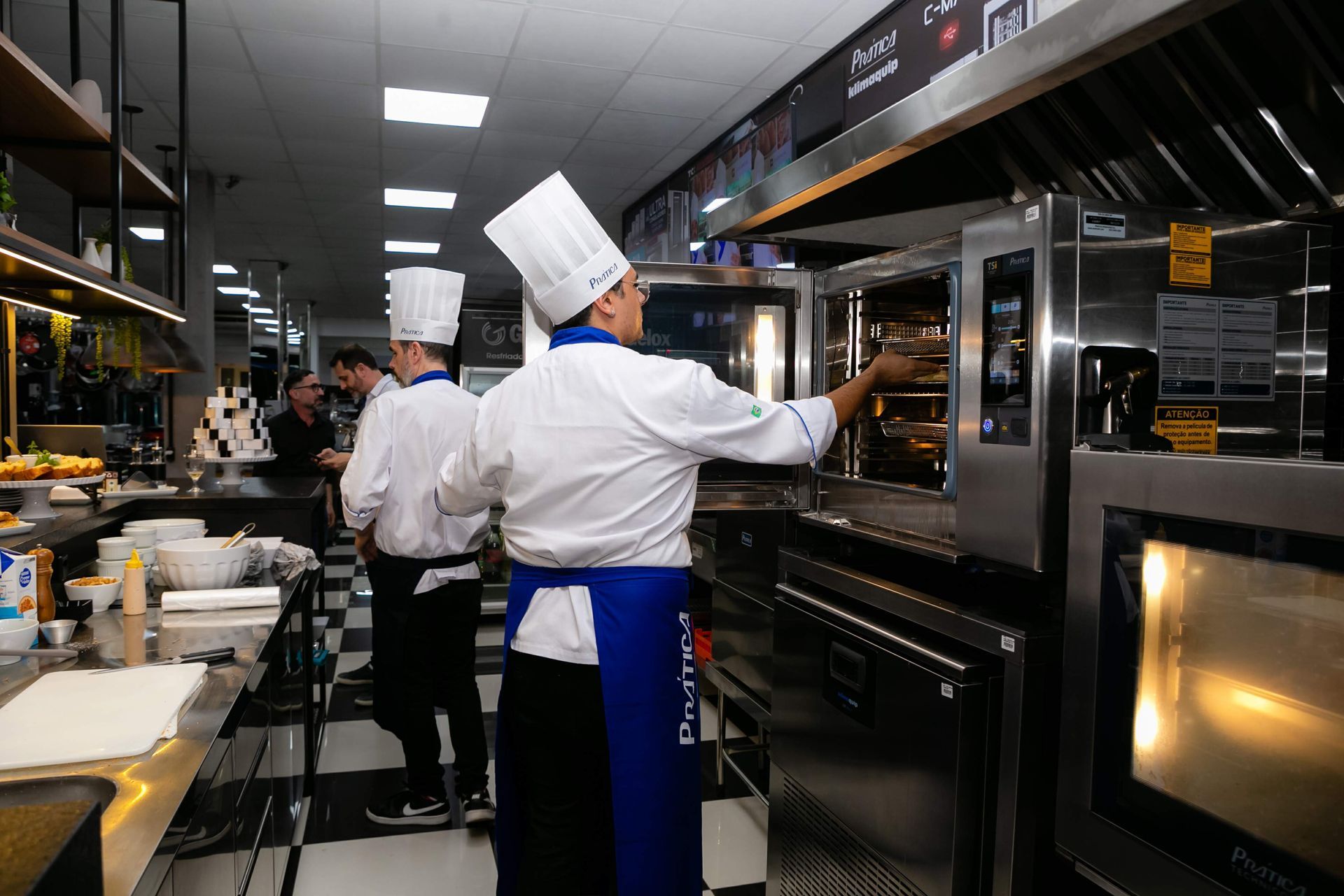 Um grupo de chefs está trabalhando em uma cozinha.