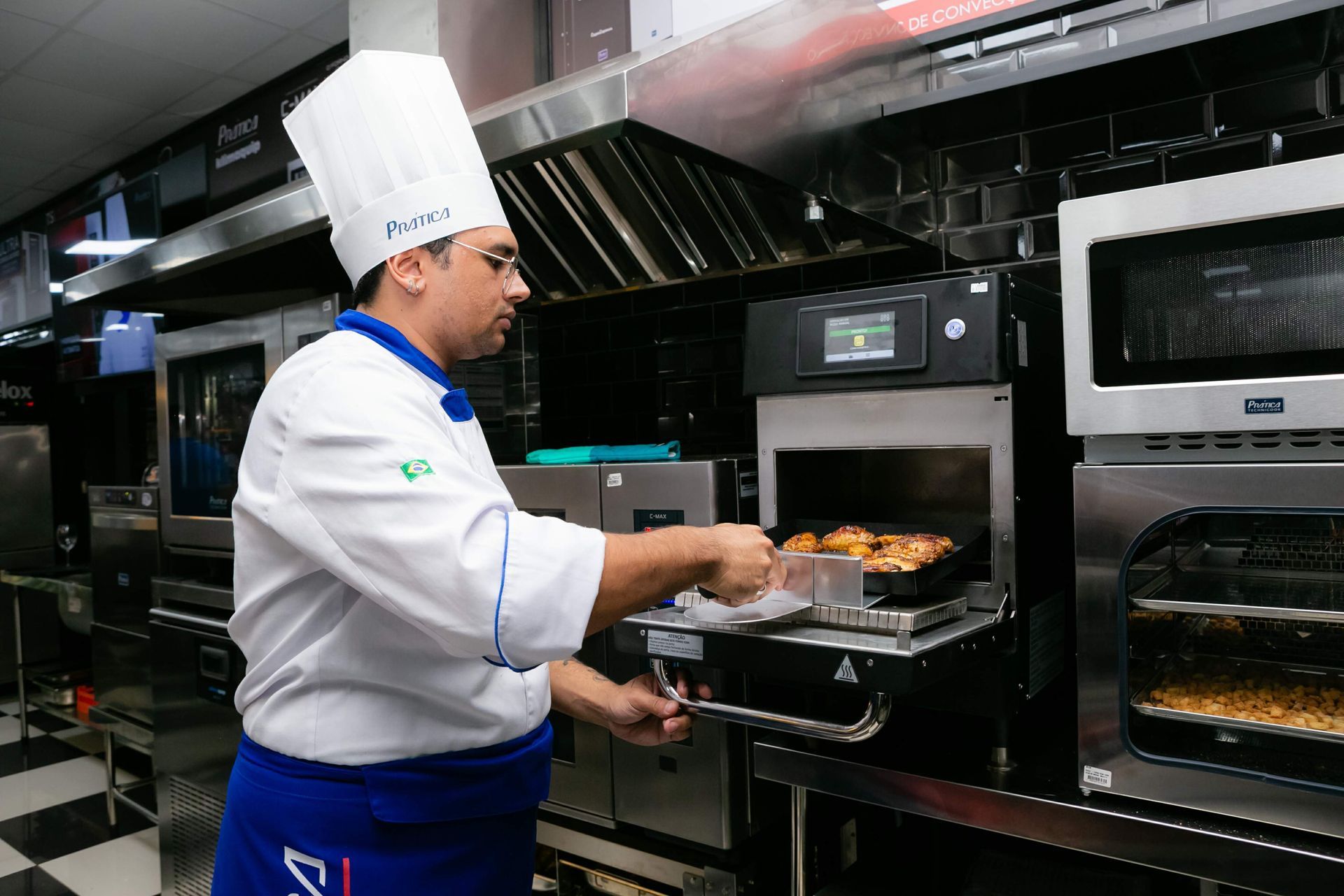 Um chef está tirando comida do forno em uma cozinha.