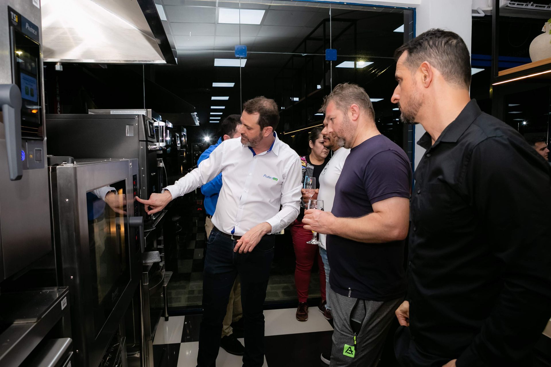Um grupo de homens está olhando para um forno em uma cozinha.