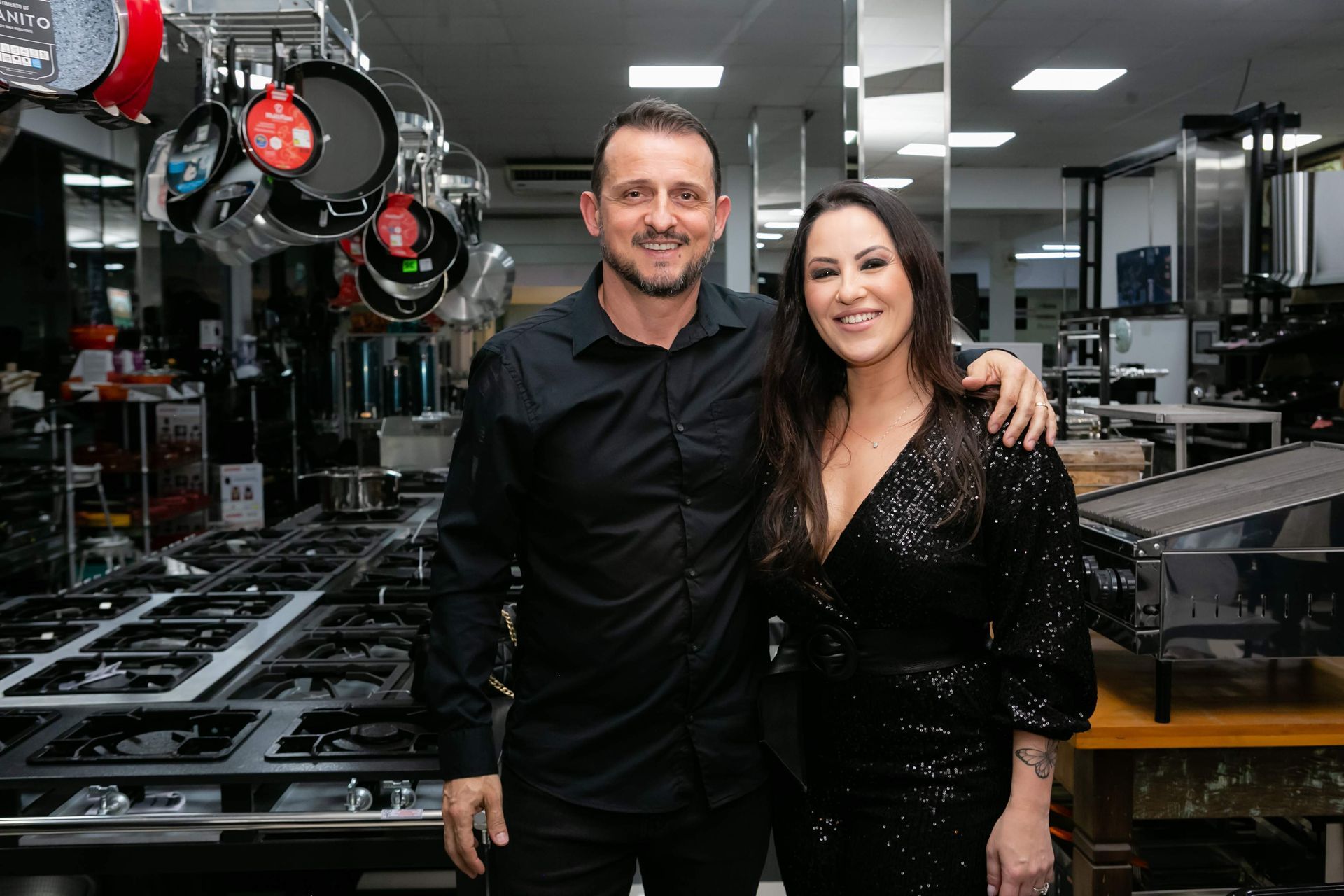 Um homem e uma mulher estão parados um ao lado do outro em uma cozinha.