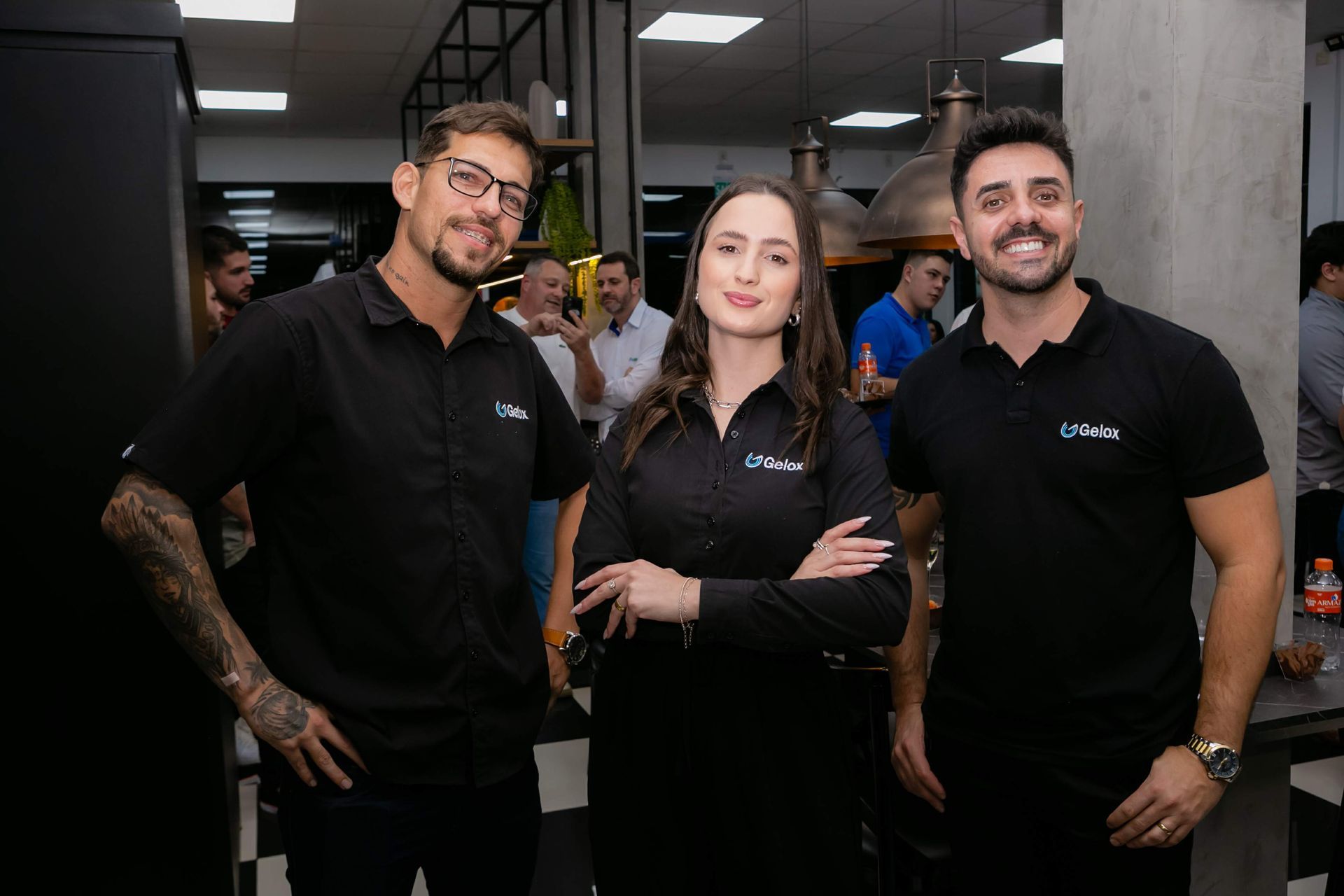 Um grupo de pessoas em pé, uma ao lado da outra, em uma sala.