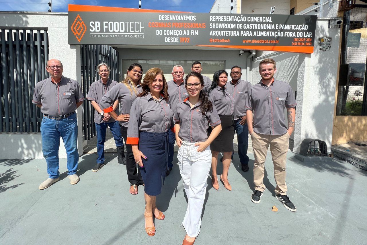 Um grupo de pessoas está posando para uma foto em frente a um prédio.