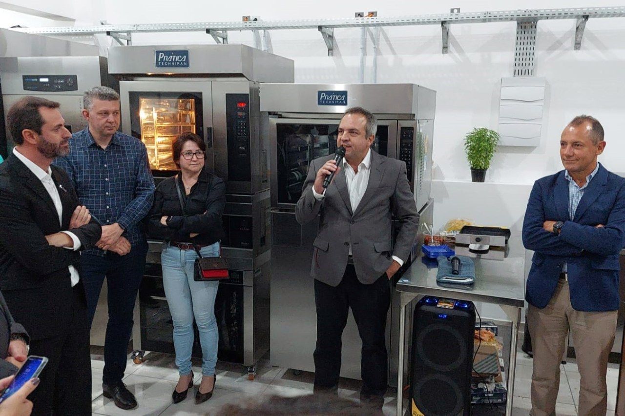 Um grupo de pessoas está em volta de um homem segurando um microfone.