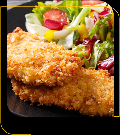 Um prato preto coberto com frango frito e uma salada.