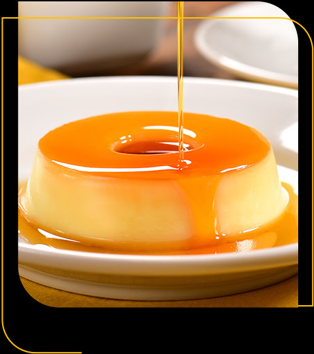 Um prato branco coberto com um pudim coberto com calda de caramelo.