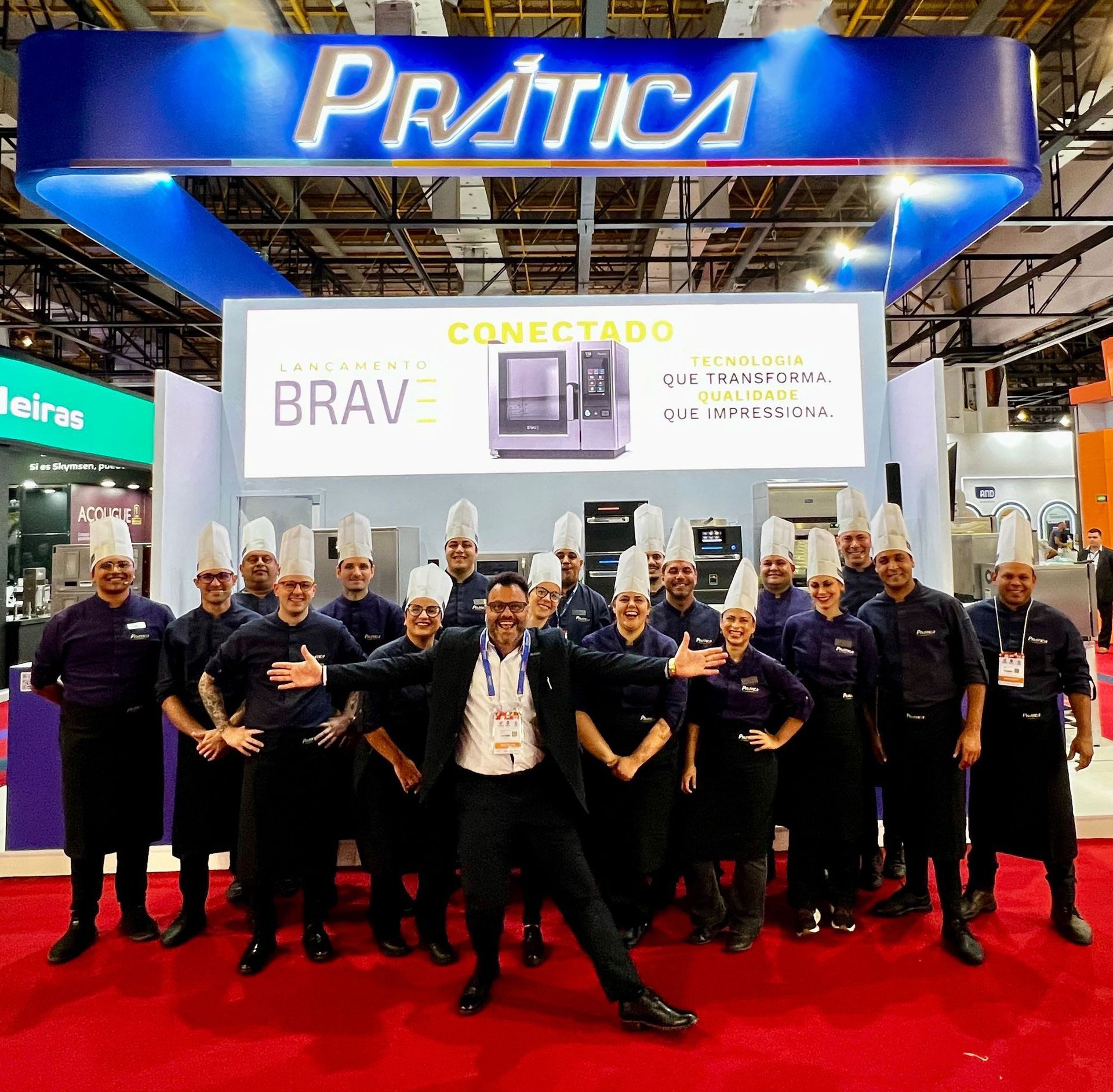 Um grupo de pessoas posando em frente a uma placa que diz pratica