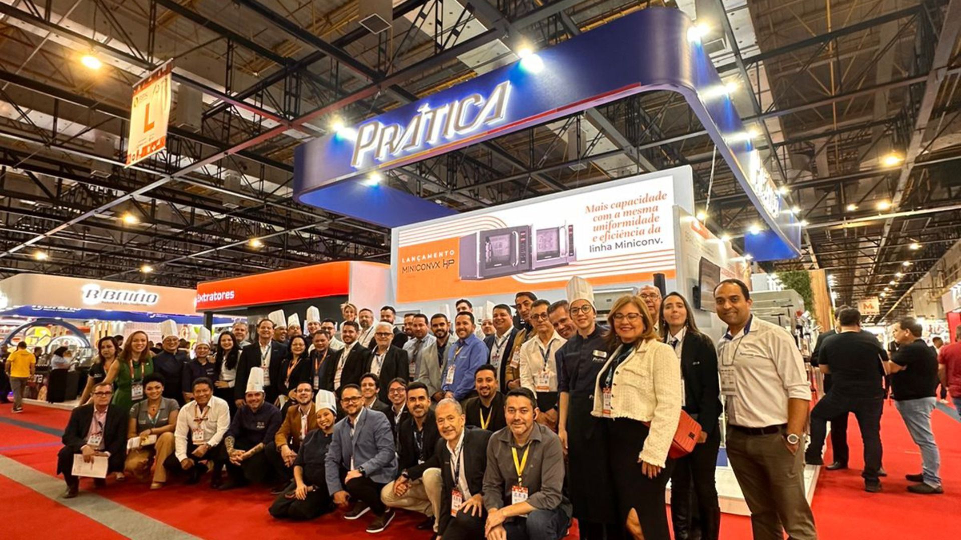 Um grupo de pessoas está posando para uma foto em uma convenção.