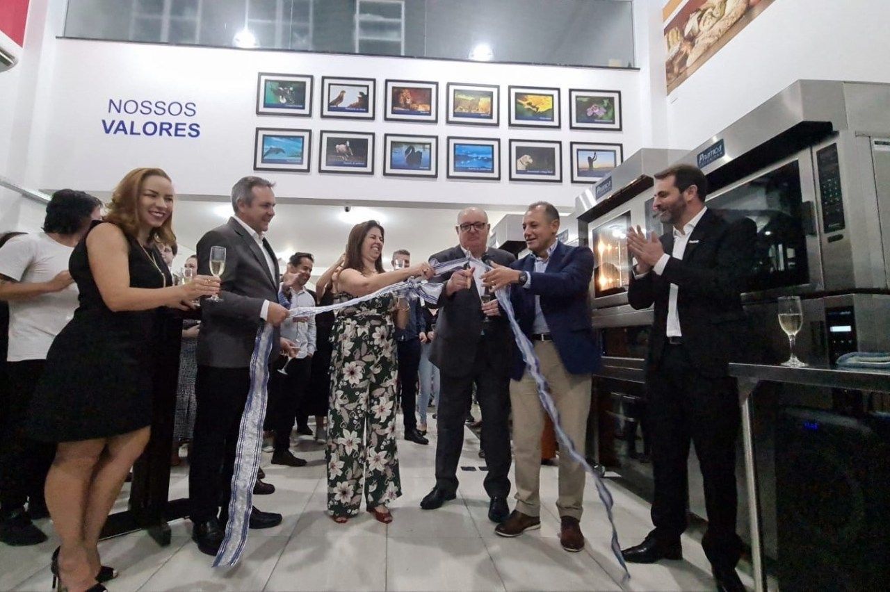 Um grupo de pessoas está em frente a uma placa que diz nossos valores