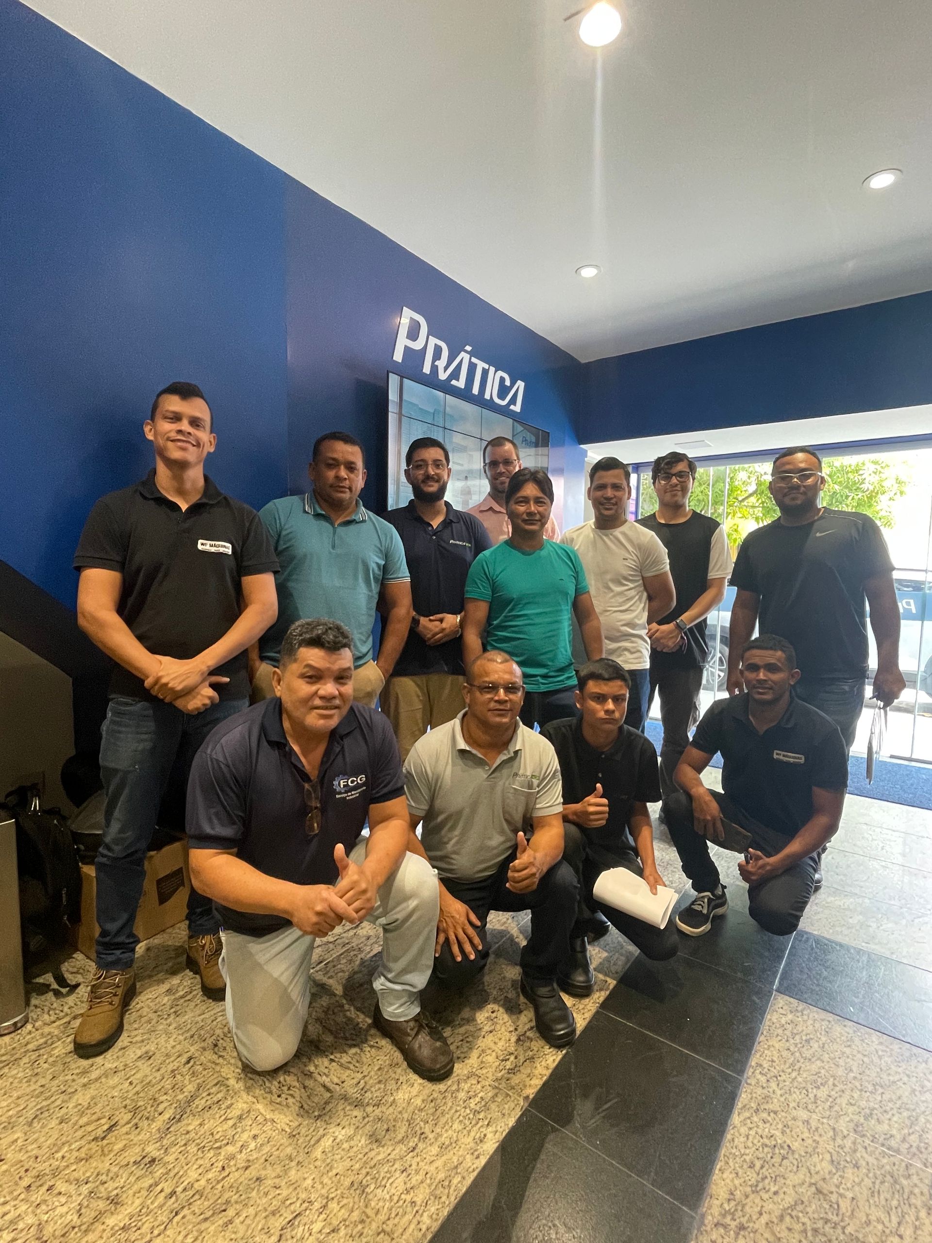 Um grupo de homens em trajes casuais posa para uma foto no saguão de um escritório