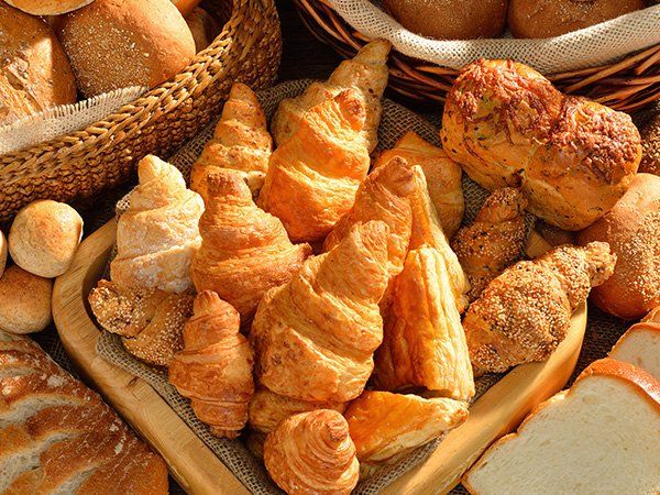 Uma variedade de pães e doces estão sobre uma mesa