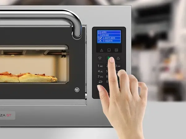 Uma pessoa está apertando um botão em um forno de pizza.