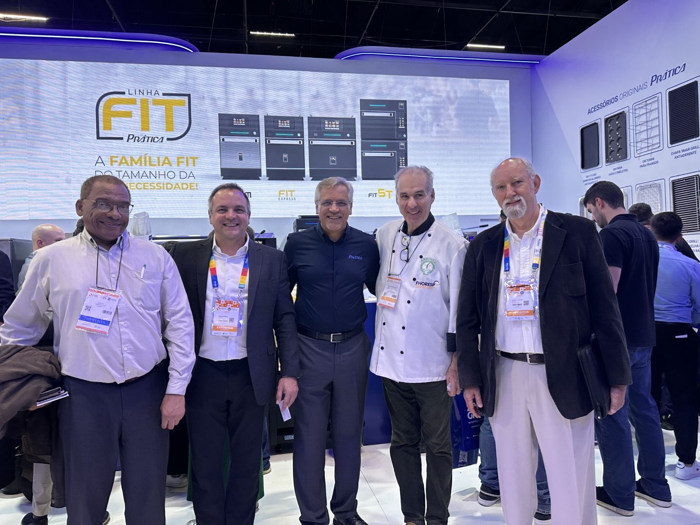 Um grupo de homens está posando para uma foto em uma convenção.