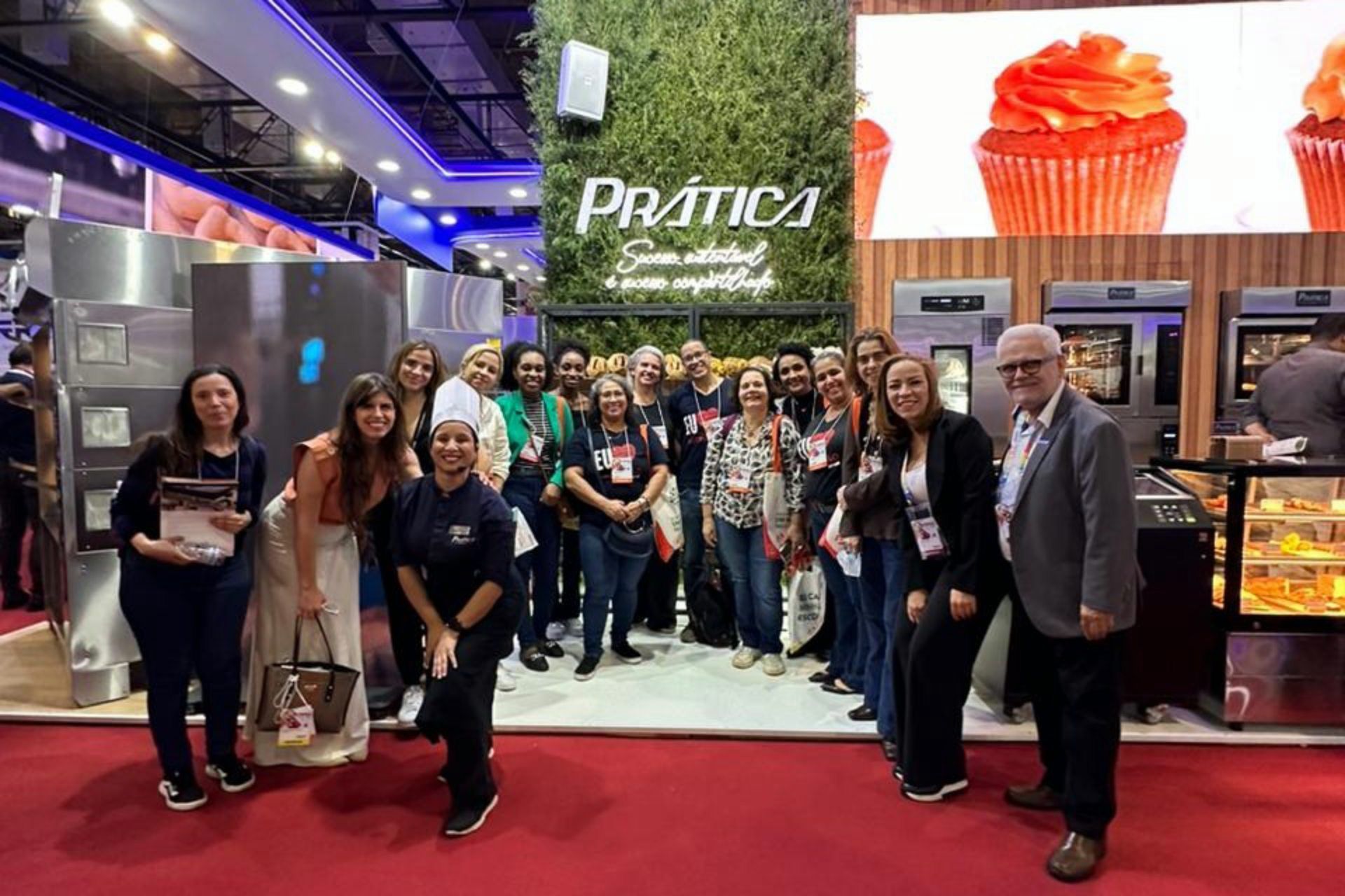 Um grupo de pessoas está posando para uma foto em uma convenção.