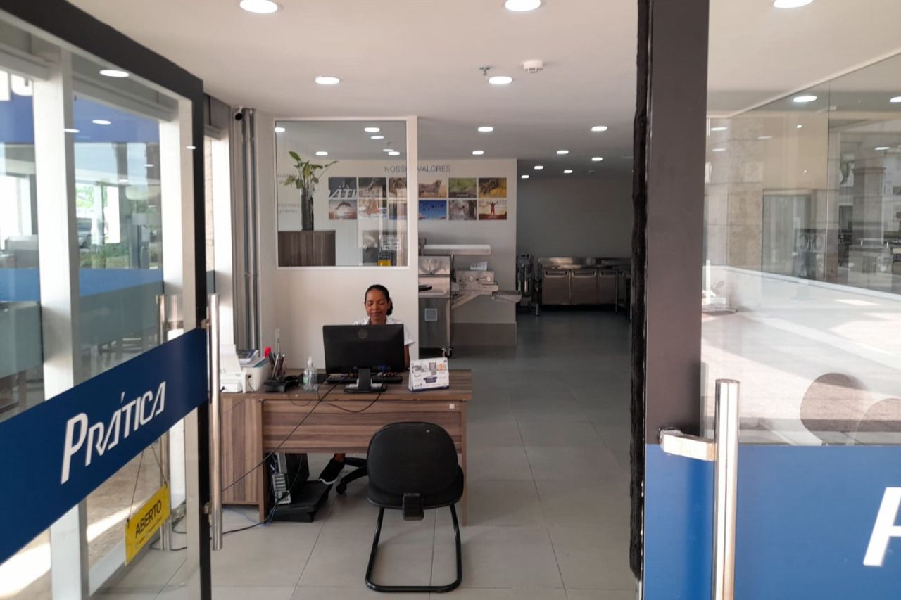 Um homem está sentado em uma mesa em um escritório com um computador.