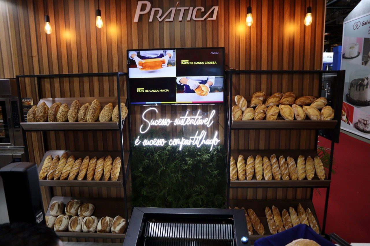 Uma exposição de pães em uma padaria com um letreiro de neon que diz prática