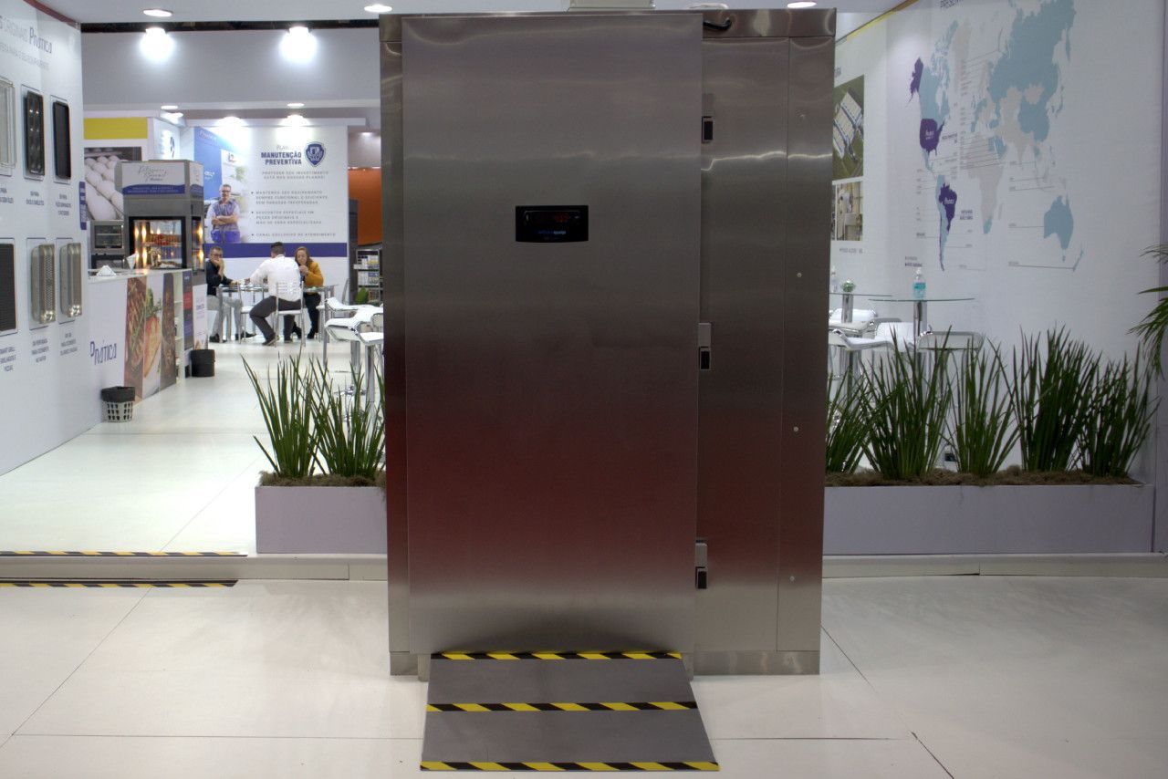 Uma grande porta de aço inoxidável está no chão de uma sala.