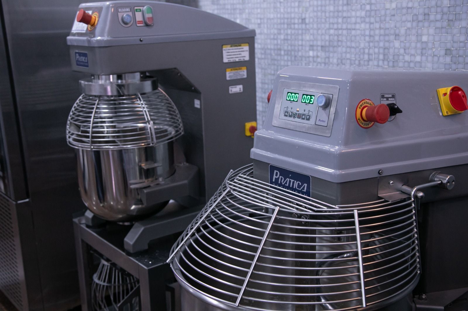 Duas batedeiras industriais em uma cozinha.