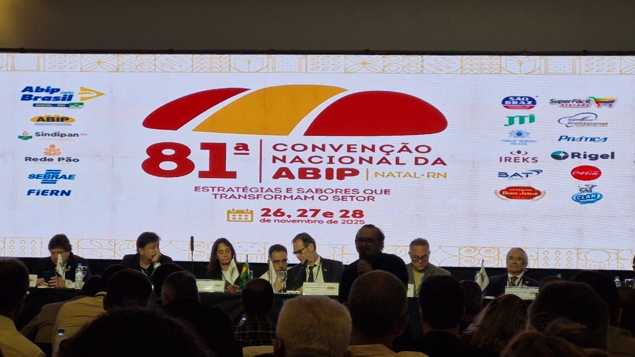 Um palco de conferência com palestrantes e uma tela exibindo o logotipo da 81ª Convenção Nacional em Natal.