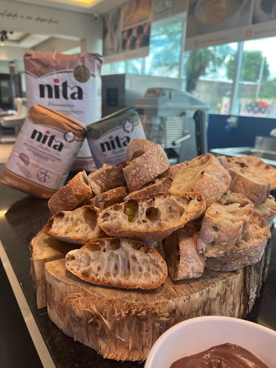 Fatias de pão sobre uma base de madeira com sacos de farinha