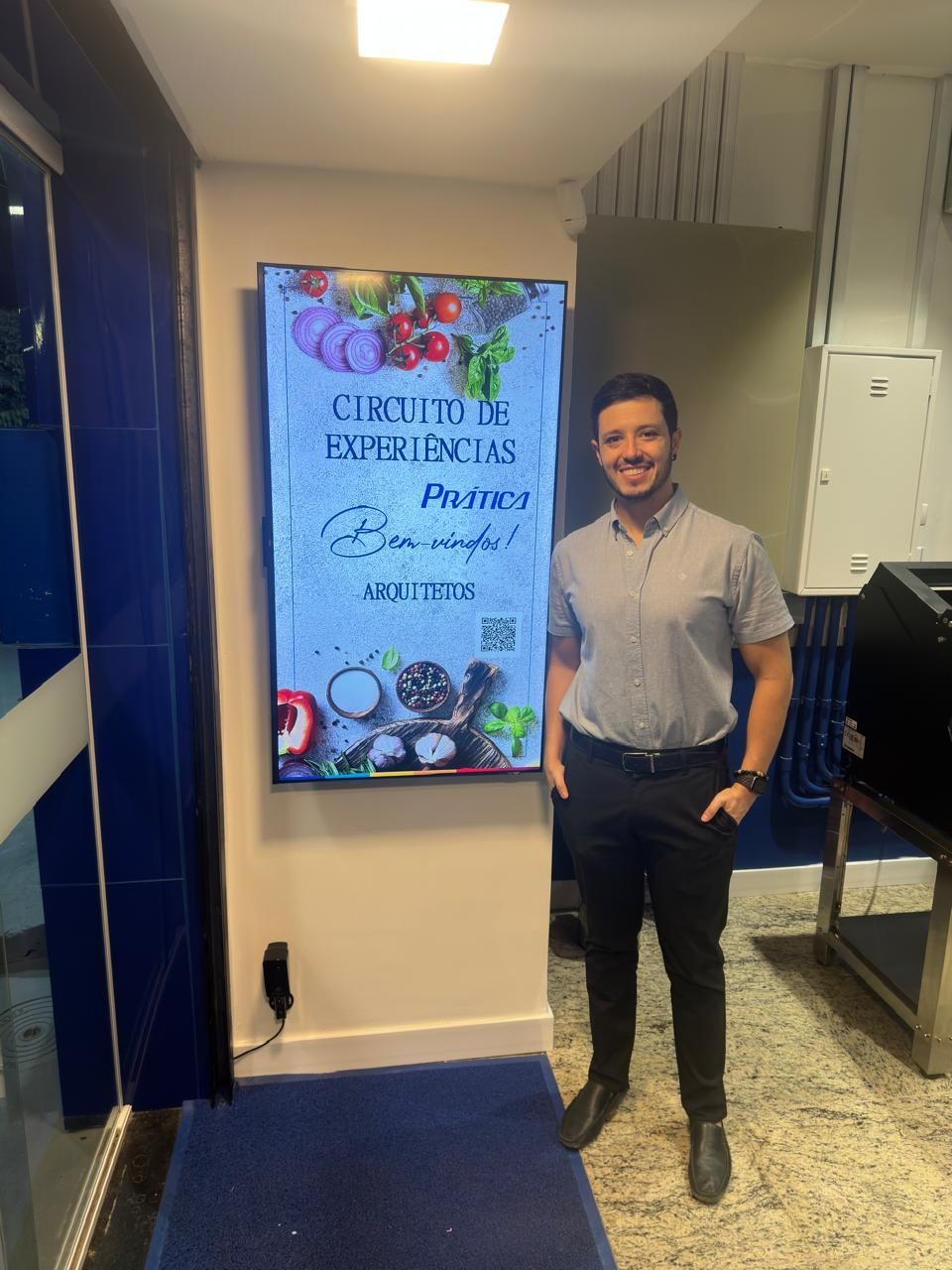 Man standing near a digital sign advertising
