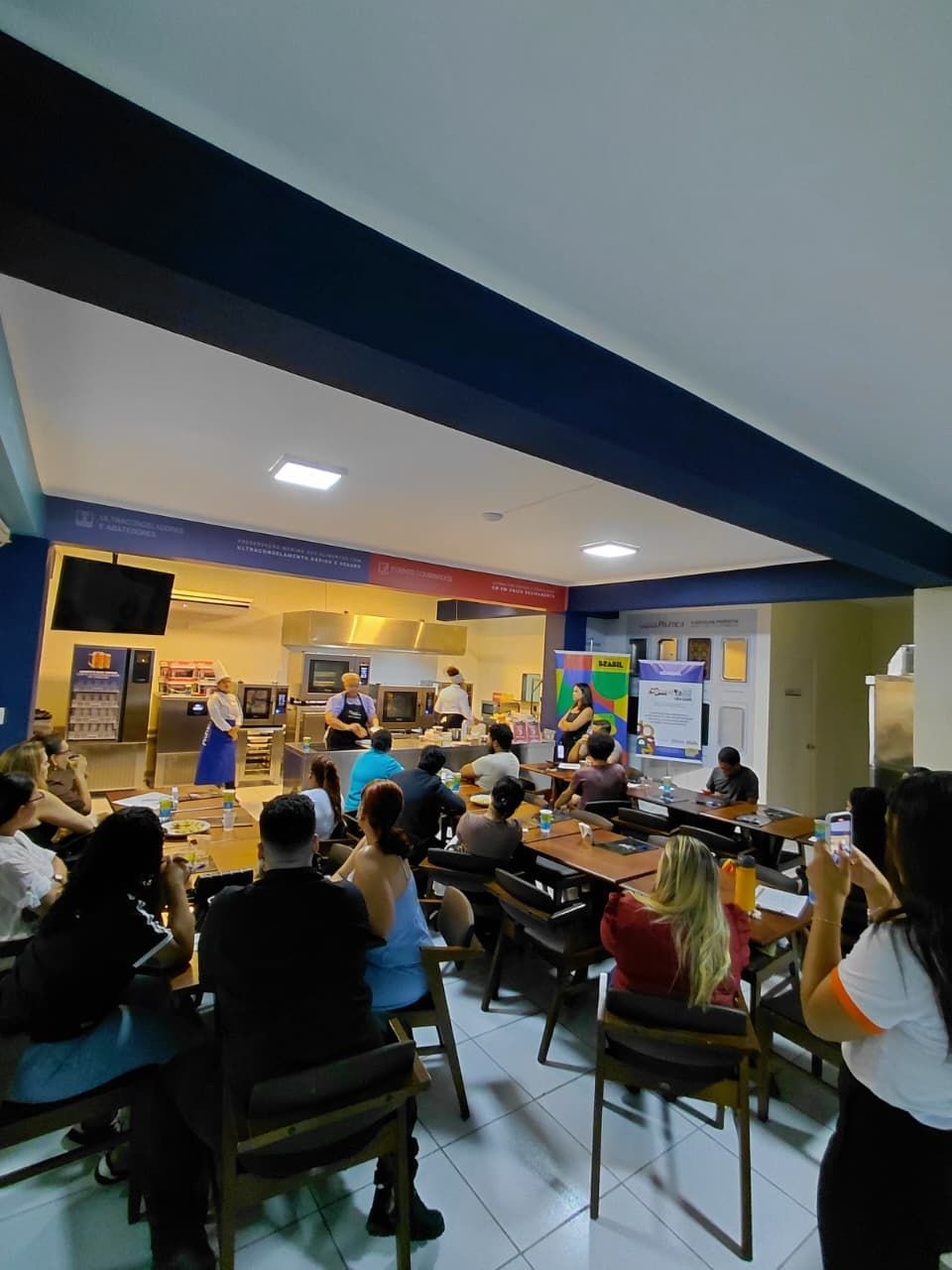 Pessoas assistindo a uma apresentação em uma sala