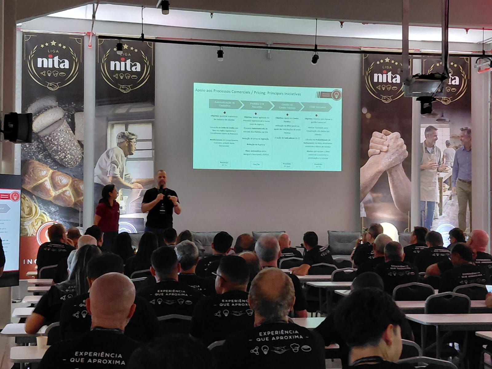Um palestrante apresenta um slide de negócios para uma plateia sentada