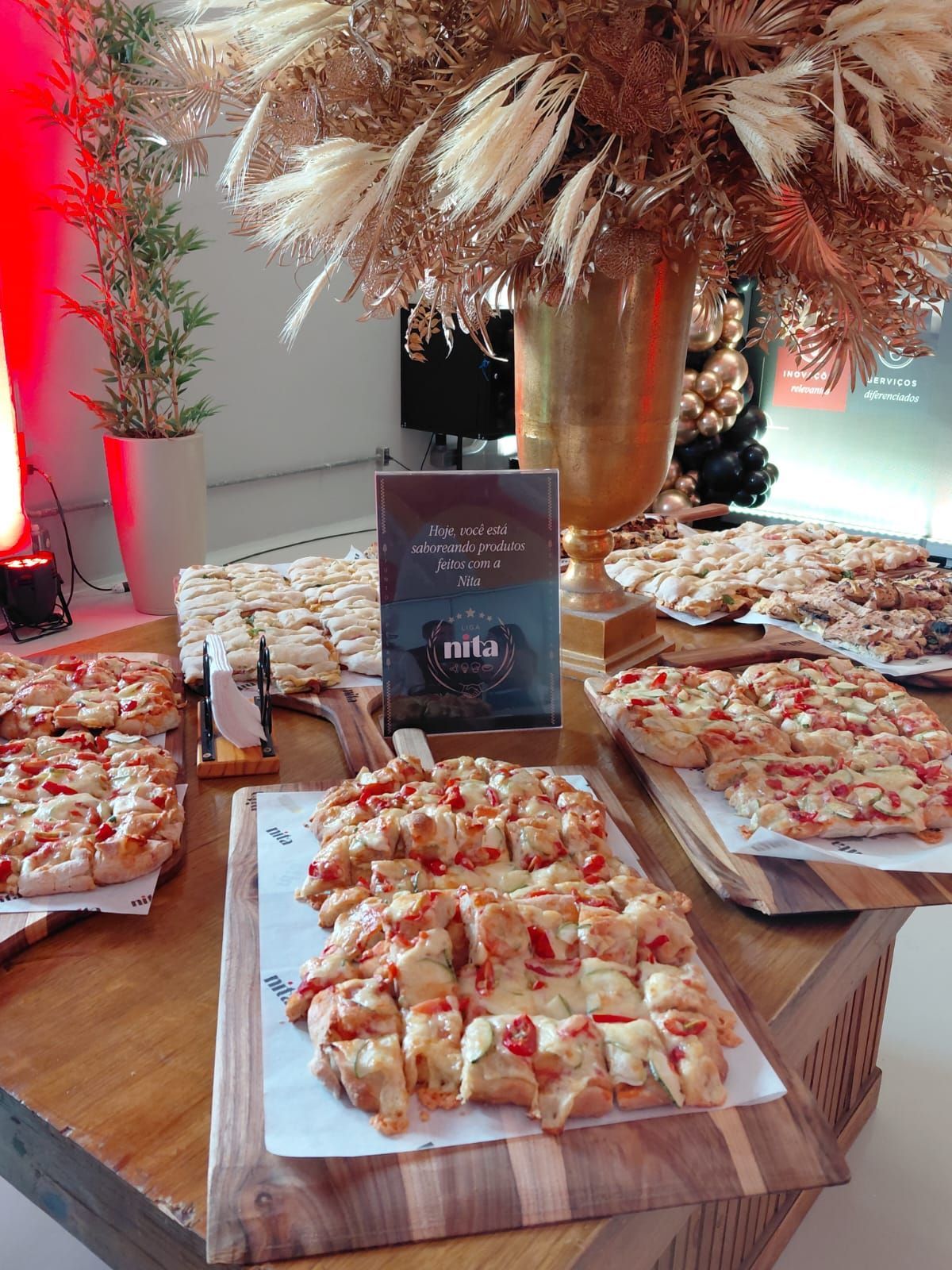 Uma seleção de pizzas quadradas em tábuas de madeira dispostas sobre uma mesa