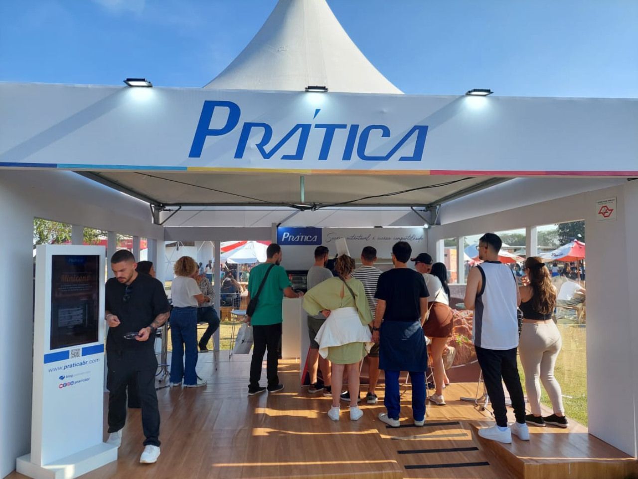 Um grupo de pessoas em pé sob uma tenda de prática