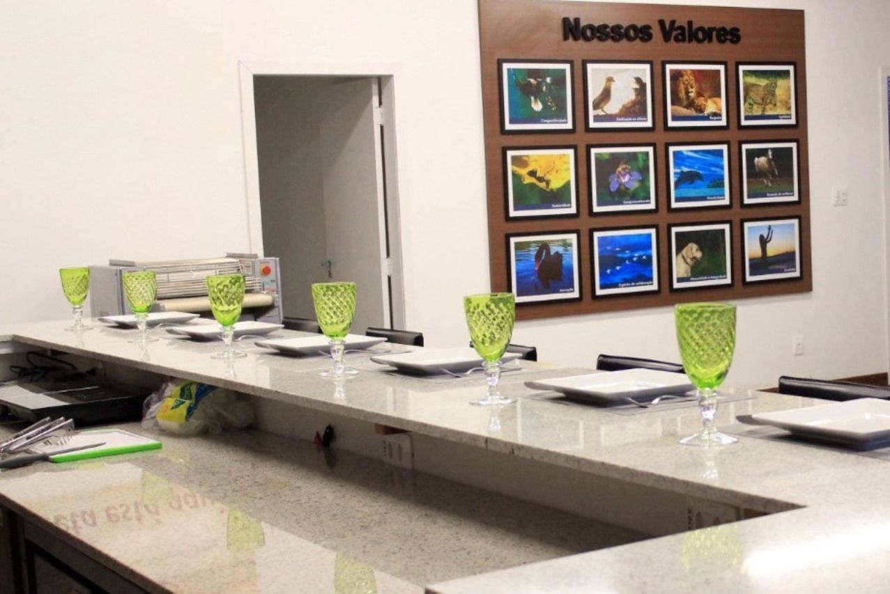 Uma mesa longa com pratos e copos sob uma placa que diz nossos valores