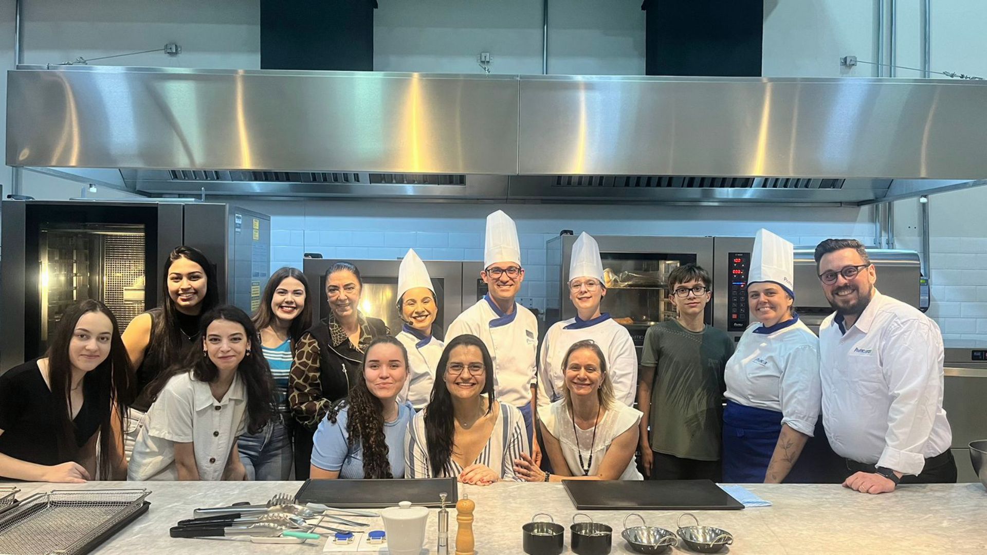 Um grupo de pessoas está posando para uma foto em uma cozinha.