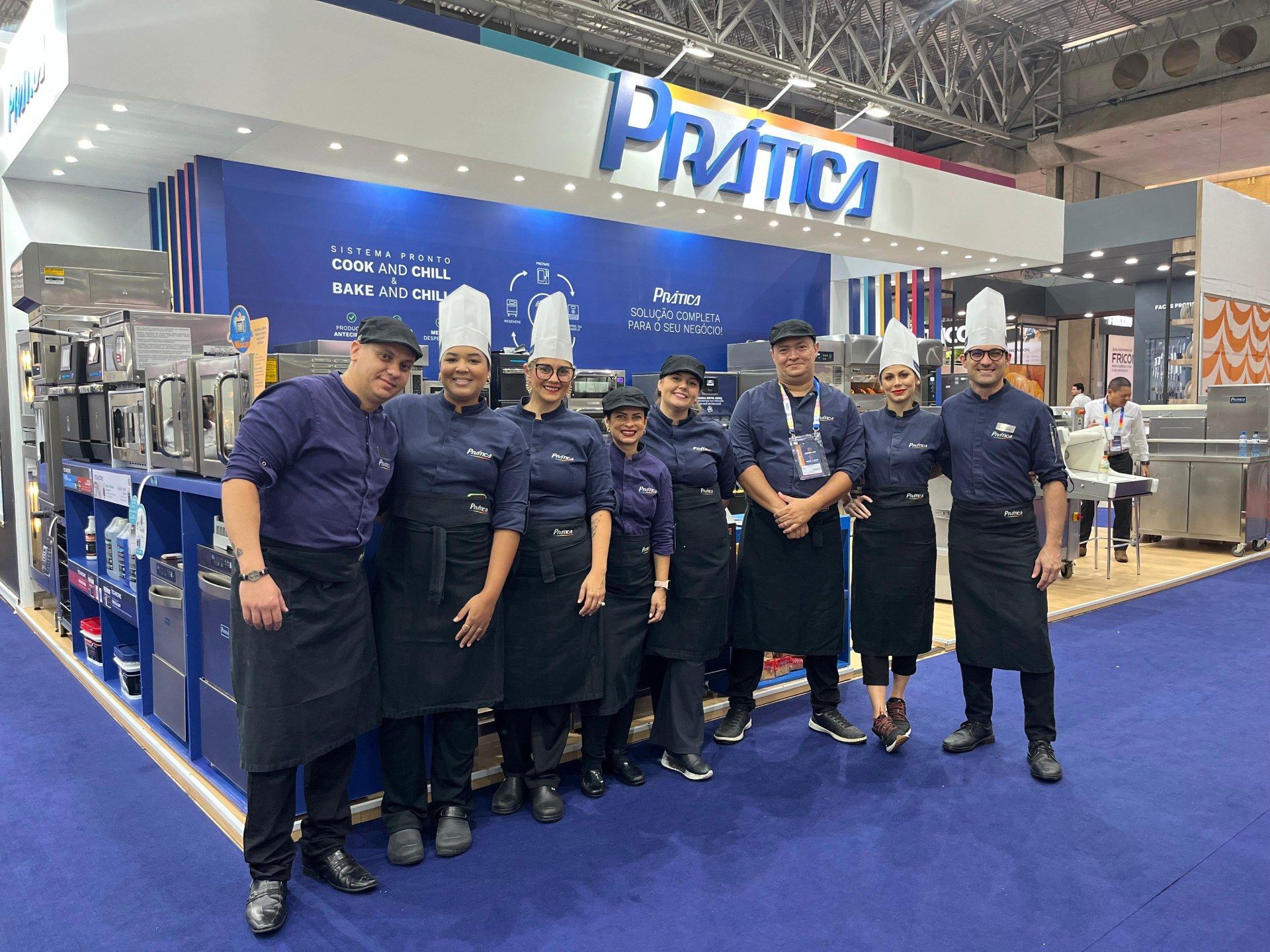 Um grupo de chefs está posando para uma foto em uma convenção.