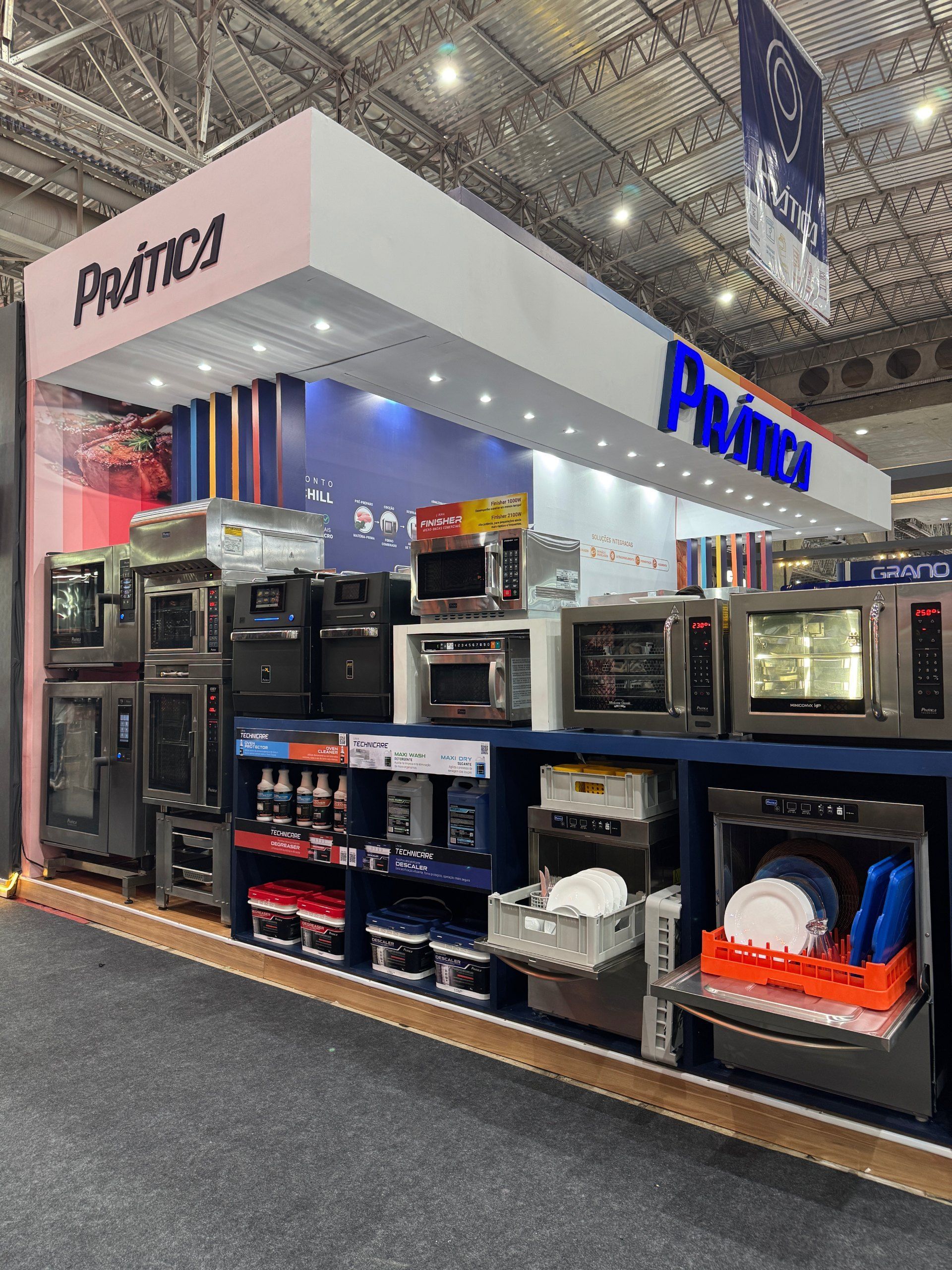 Equipamentos de cozinha comercial expostos em um estande com a placa 