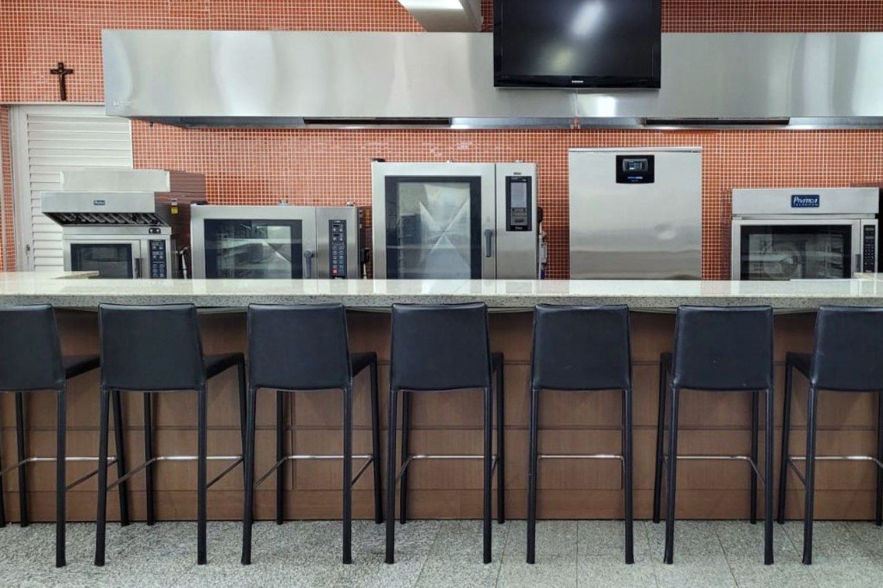 Uma cozinha com eletrodomésticos de aço inoxidável e uma cruz na parede