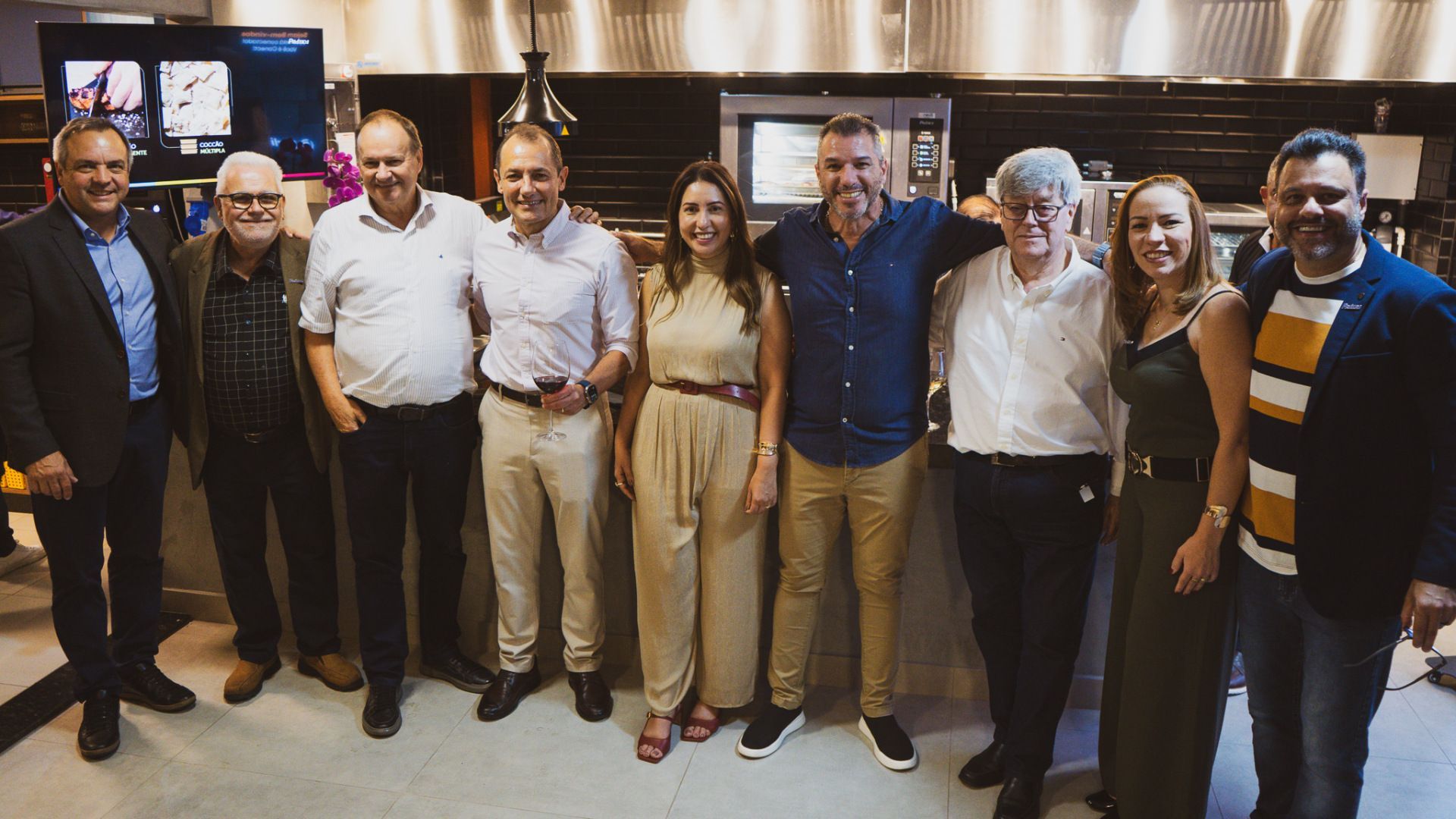 Um grupo de pessoas está posando para uma foto em uma cozinha.