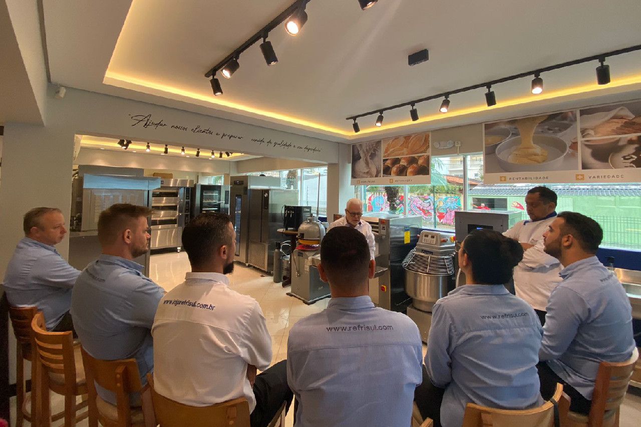 Um grupo de homens está sentado em círculo em um restaurante.