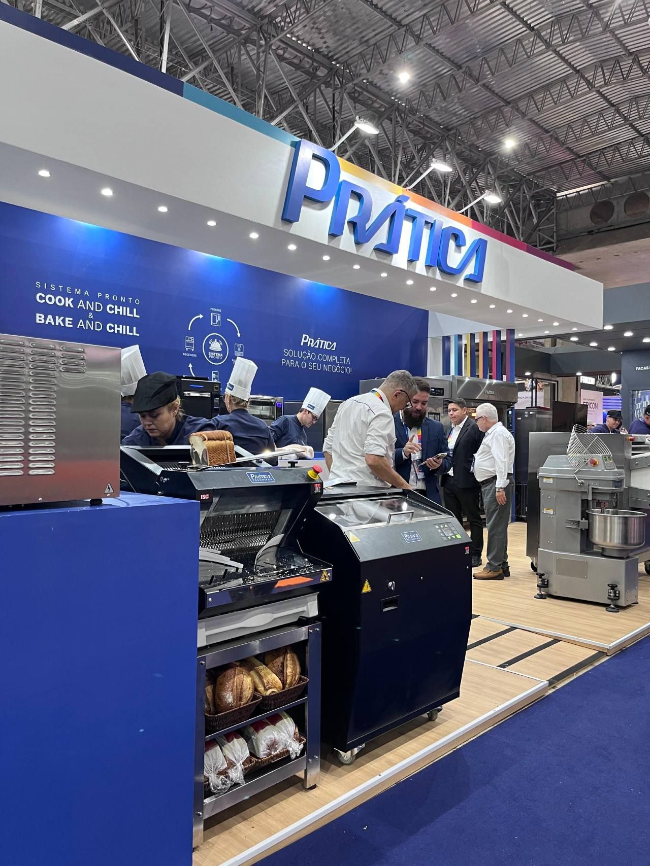 Um grupo de pessoas está em frente a uma vitrine de uma padaria.