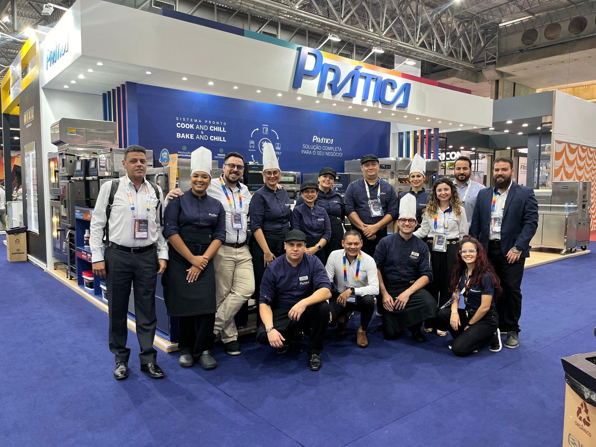 Um grupo de pessoas está posando para uma foto em uma convenção.