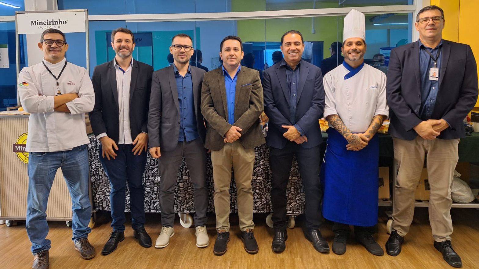 Um grupo de homens parados um ao lado do outro em uma sala.