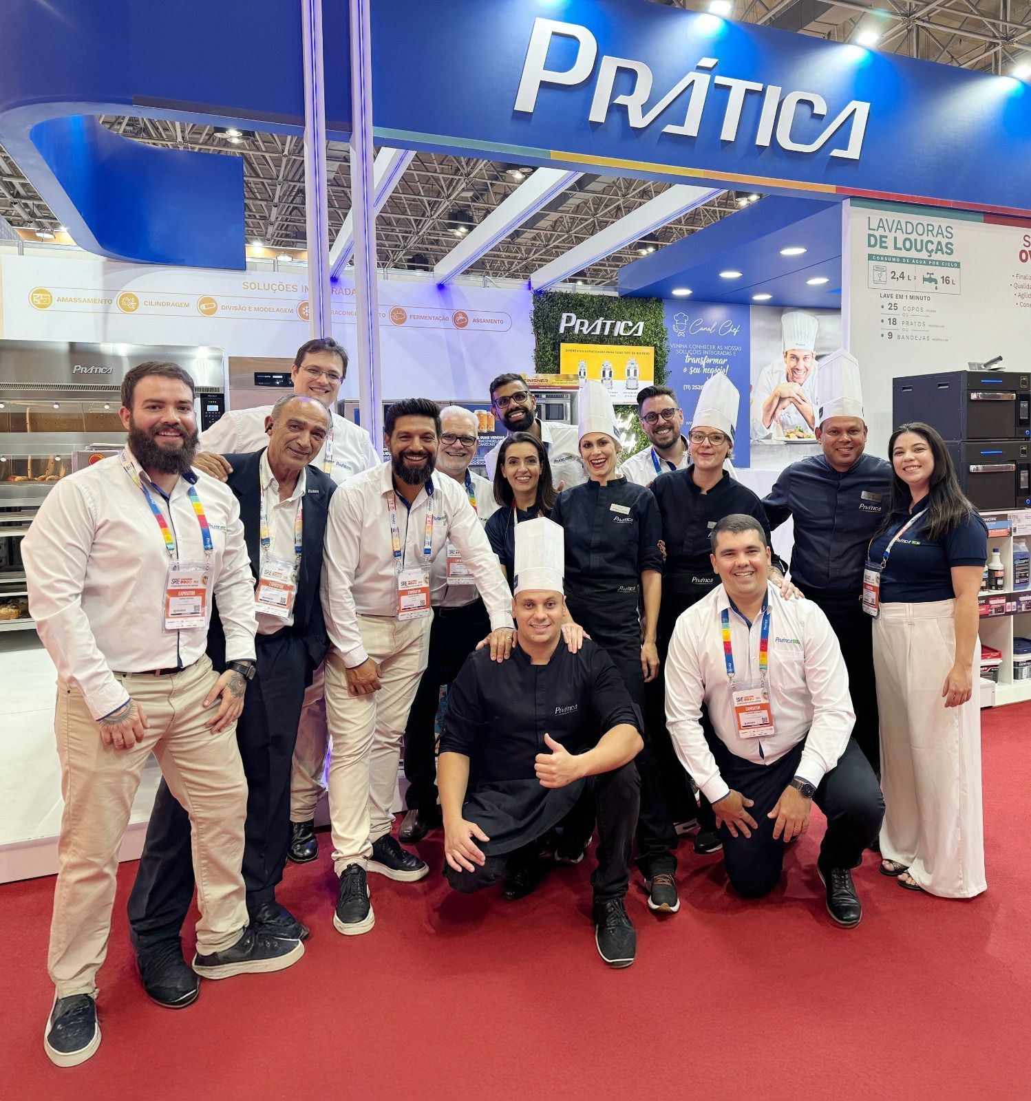 Um grupo de pessoas está posando para uma foto em uma convenção.