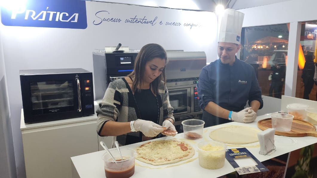 Um homem e uma mulher estão preparando pizzas